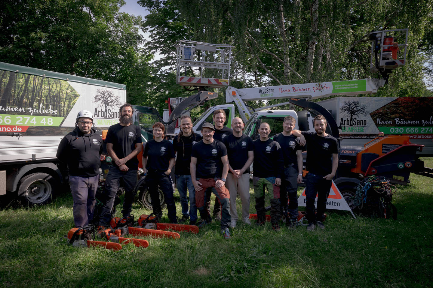 Das Team von ArboSano vor dem eigenen Fuhrpark mit Hebebühne und Großhäckslern im Großraum Berlin